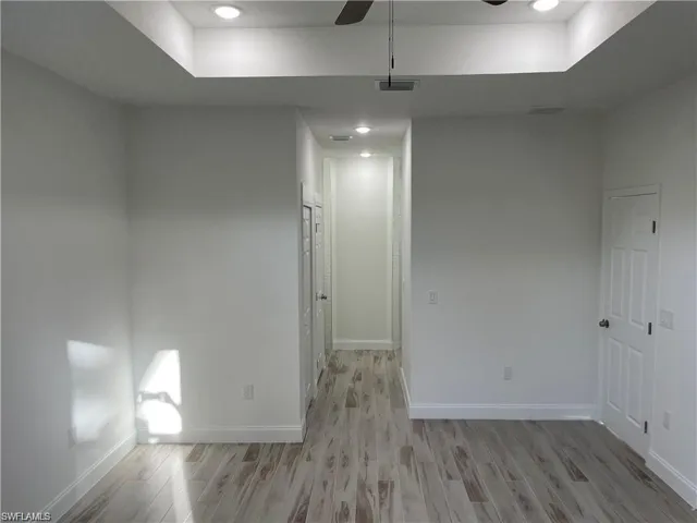 Empty room with ceiling fan and light hardwood / wood-style flooring