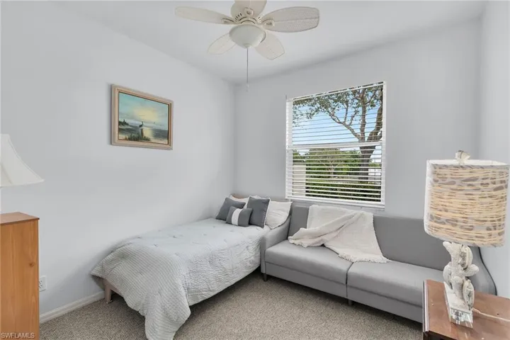 Carpeted bedroom with a ceiling fan and baseboards