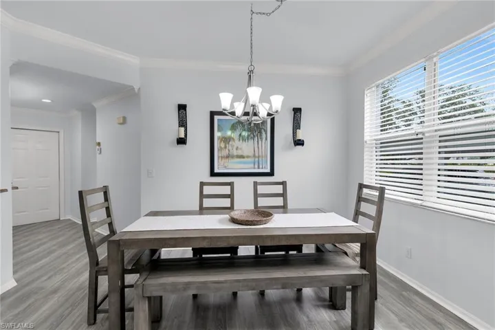 Dining space featuring ornamental molding, a chandelier, and light wood-type flooring