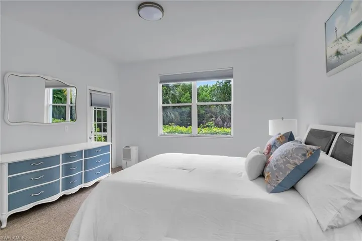 Bedroom featuring multiple windows and dark carpet