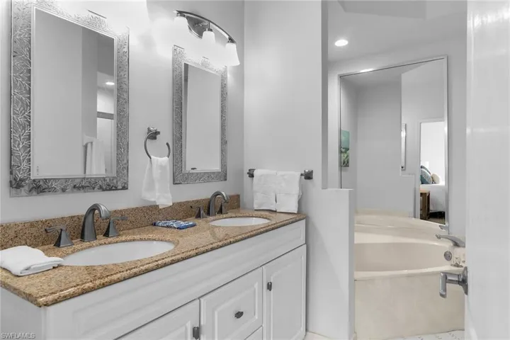Full bathroom featuring double vanity, a garden tub, ensuite bathroom, and recessed lighting