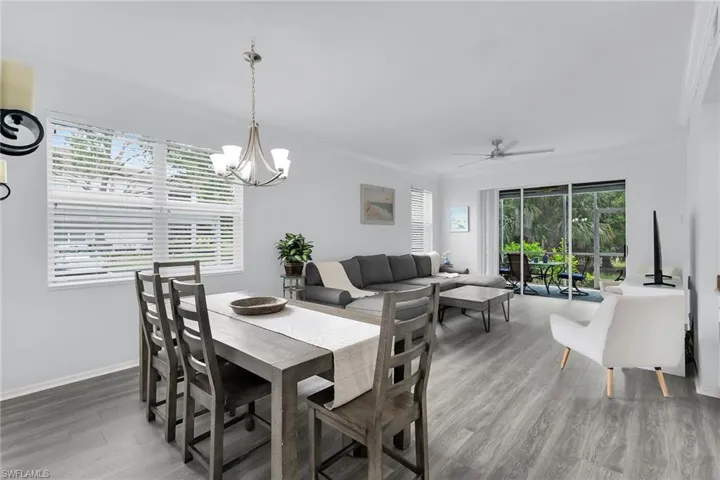 Dining space featuring light wood-type flooring, a ceiling fan, and a chandelier