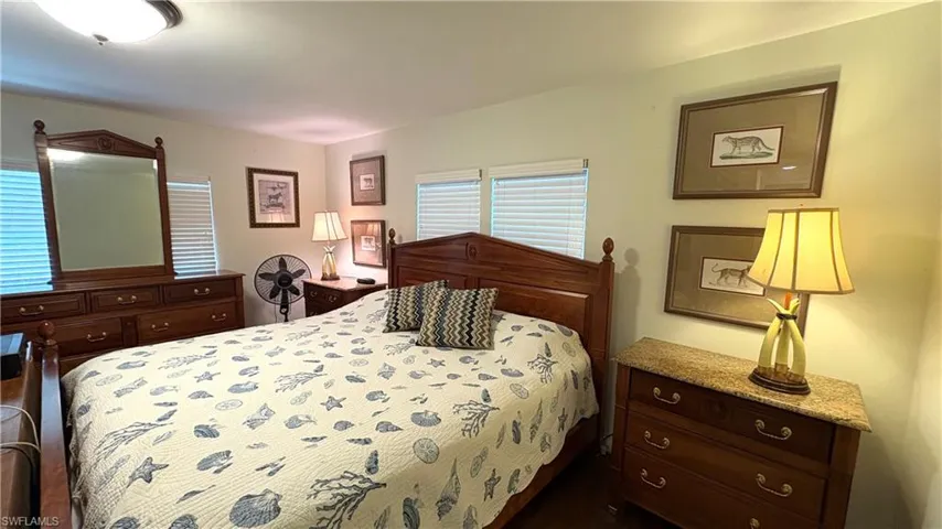 Primary Bedroom features wood-finish flooring, two large windows with blinds, snd ceiling light fixture.