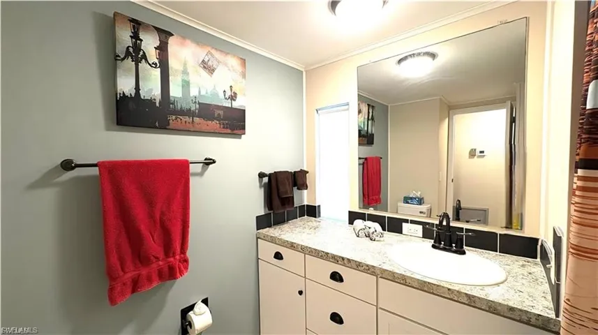 Hall Bathroom has a granite-finish countertop and shower, with integrated sink, patterned countertop, and black tile backsplash