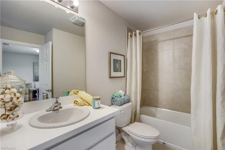 Full bathroom with shower / bath combination with curtain, toilet, and vanity