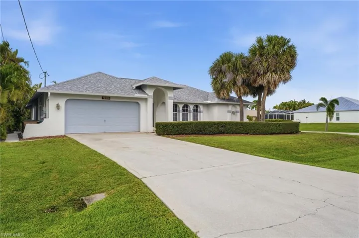 White stucco exterior with a gray shingle roof and an attached garage