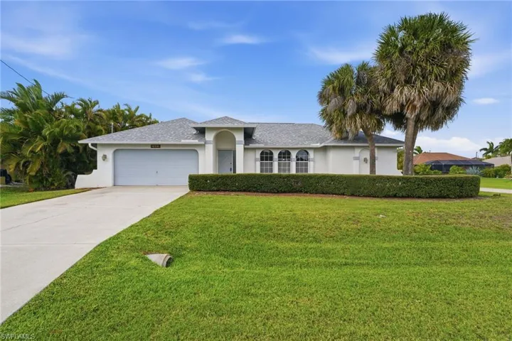 Exterior residence featuring an arched portico entry and a two-car garage