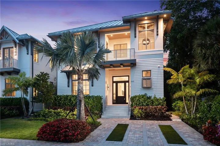 View of front of house with a balcony, a standing seam roof, metal roof, and stucco siding