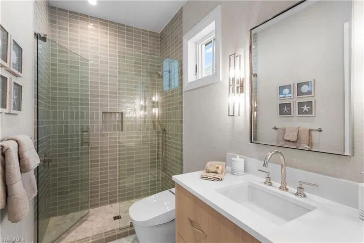 Full bath with toilet, vanity, and a shower stall