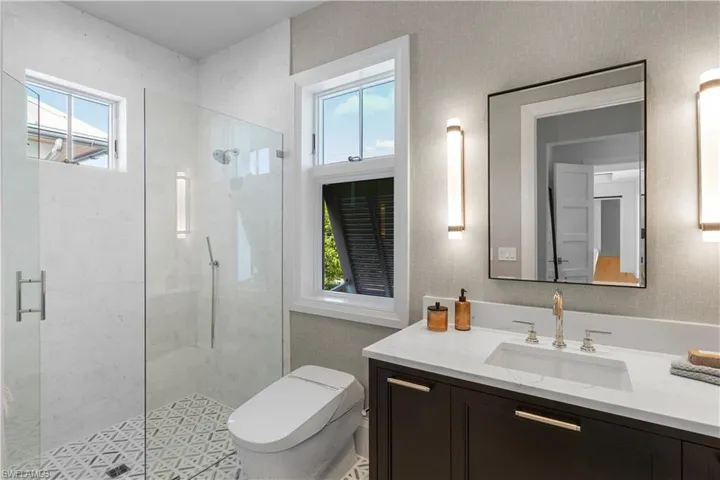 Bathroom featuring vanity, a stall shower, and toilet
