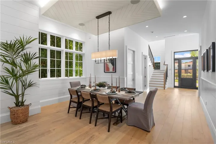 Dining area featuring light wood finished floors, stairway, and baseboards