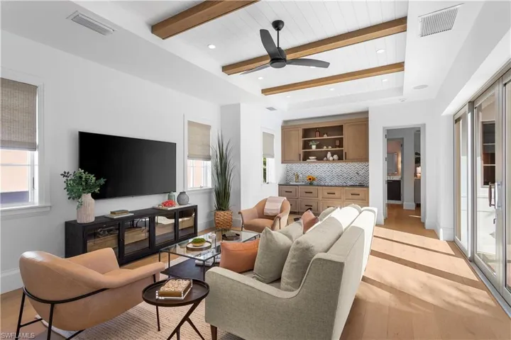 Living room featuring light wood finished floors, beam ceiling, ceiling fan, recessed lighting, and baseboards