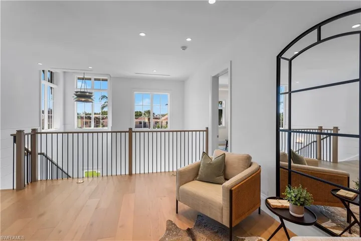 Sitting room featuring wood finished floors, recessed lighting, and an upstairs landing