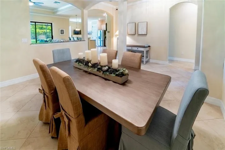 Tiled dining space with ceiling fan and ornamental molding
