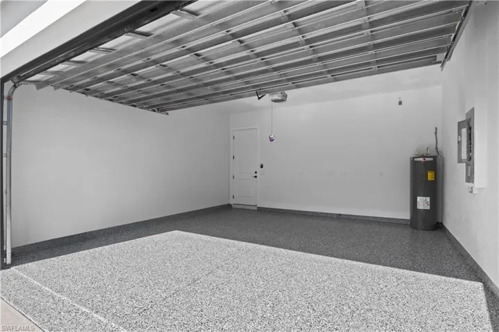 Garage featuring water heater and electric panel