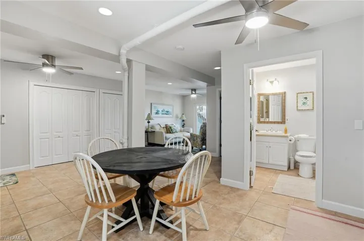 Dining room with ceiling fan, light tile patterned floors, and recessed lighting