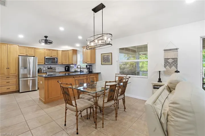 Dining room featuring light tile patterned floors, recessed lighting, and a chandelier
