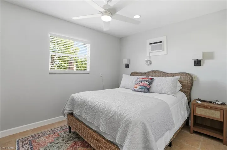 Bedroom with ceiling fan and a wall unit AC