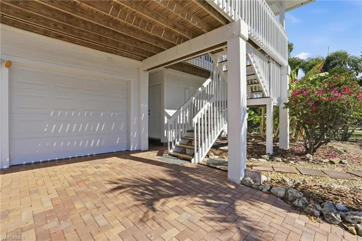 View of patio / terrace with stairway, a garage, and decorative driveway