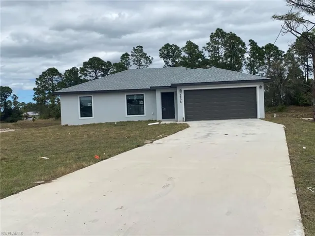 Ranch-style home featuring a garage and a front lawn
