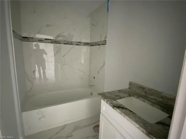 Bathroom featuring vanity and tiled shower / bath