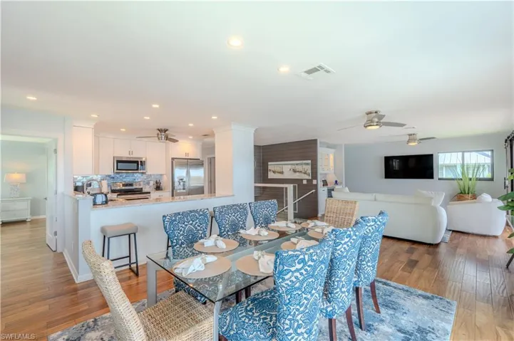 Dining area with light wood flooring, a ceiling fan, and recessed lighting - Virtually Edited Image