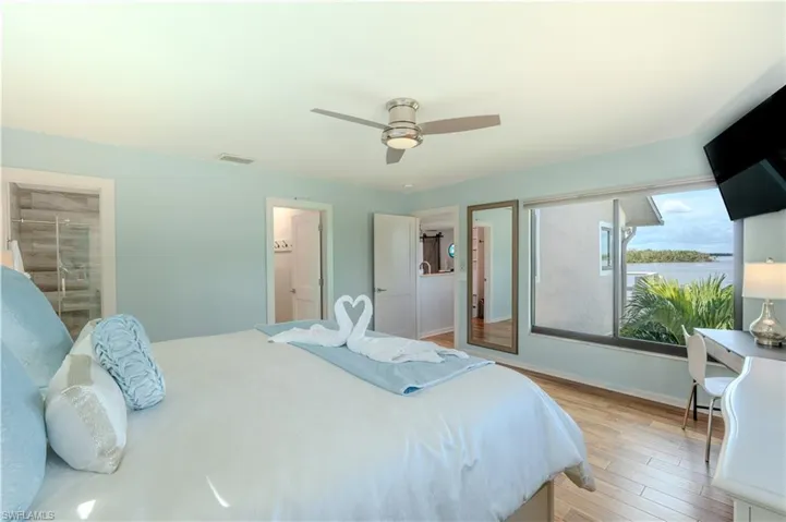 Bedroom featuring wood finished floors and a ceiling fan - Virtually Edited Image