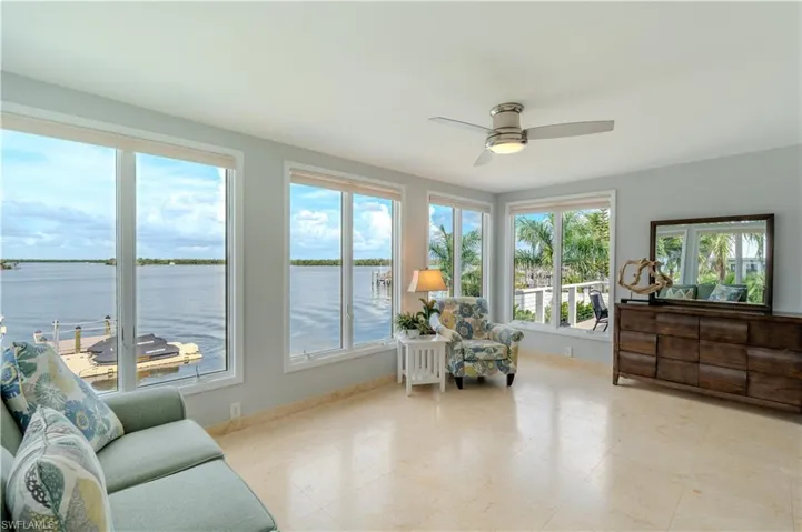 Sitting room with a water view and ceiling fan - Virtually Edited Image
