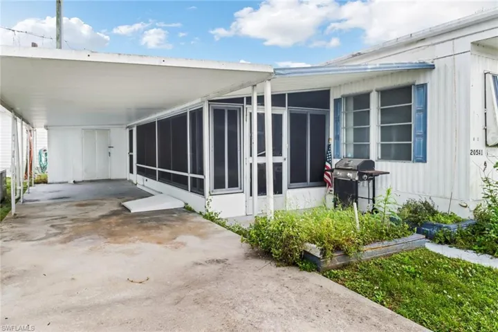 View of side of home with a sunroom and a carport