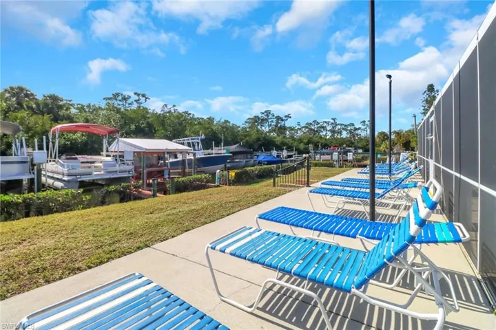 View of home's community with a lawn, a boat dock, and a patio