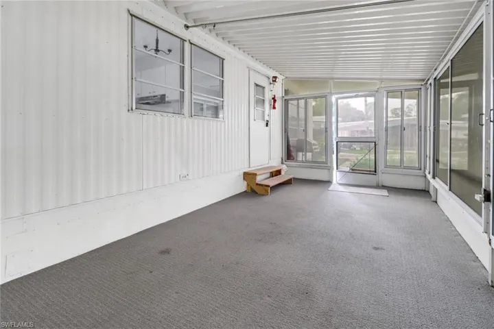 Unfurnished sunroom featuring lofted ceiling