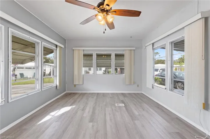 Unfurnished sunroom with a wealth of natural light and ceiling fan