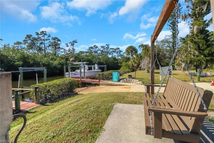 View of yard with a water view and a dock