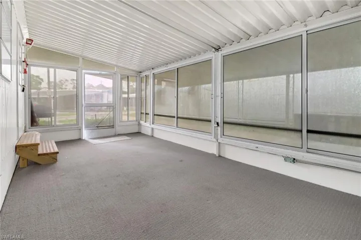 Unfurnished sunroom featuring lofted ceiling