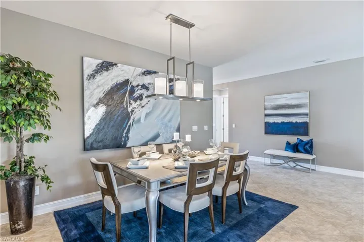 Formal dining area featuring a rectangular chandelier with frosted glass shades, light grey walls, and a recessed ceiling