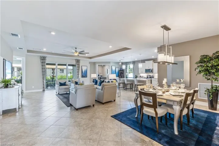 Open-concept living space showcasing tile flooring, recessed lighting, and a ceiling fan