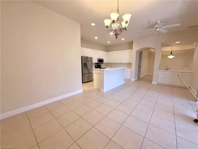 Formal Eat In Kitchen with large Dining Area and white cabinets, light countertops, light tile patterned floors, stainless steel appliances, a center island with sink, Breakfast nook with sink and Large Pocket Sliders to Courtyard