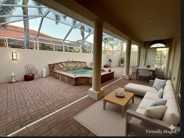 View of patio featuring outdoor lounge area, a lanai, a sunroom, and an outdoor hot tub