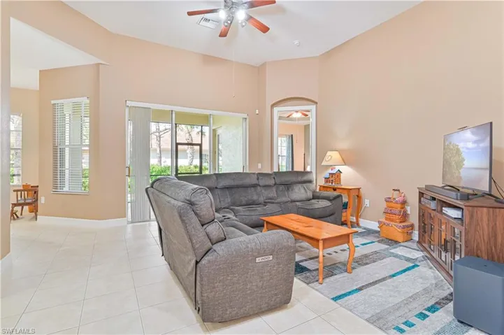 Living area featuring a ceiling fan and light tile patterned floors