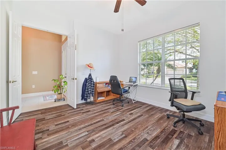 Office area featuring dark wood-type flooring and ceiling fan