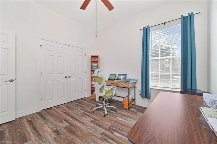 Office space with dark wood finished floors, a ceiling fan, and lofted ceiling