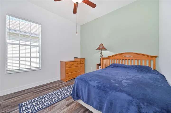 Bedroom featuring wood finished floors, a ceiling fan, and lofted ceiling
