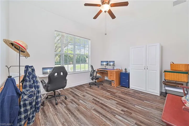 Office area with dark wood-style flooring and a ceiling fan