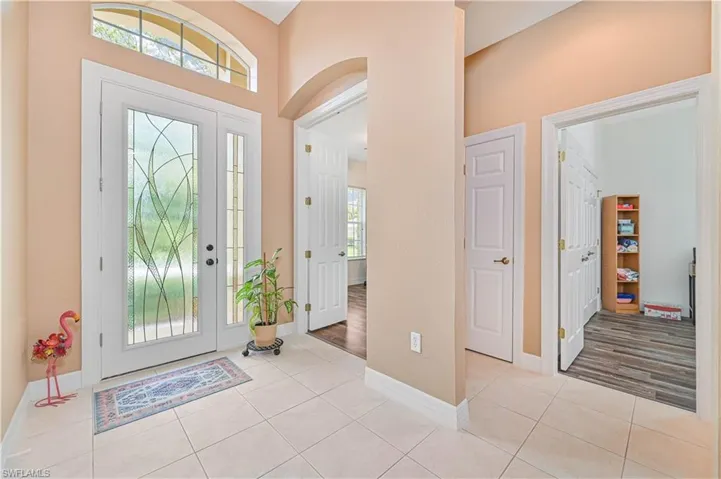 Foyer featuring arched walkways and light tile patterned floors
