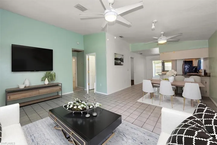 Living area with ceiling fan and light tile patterned floors