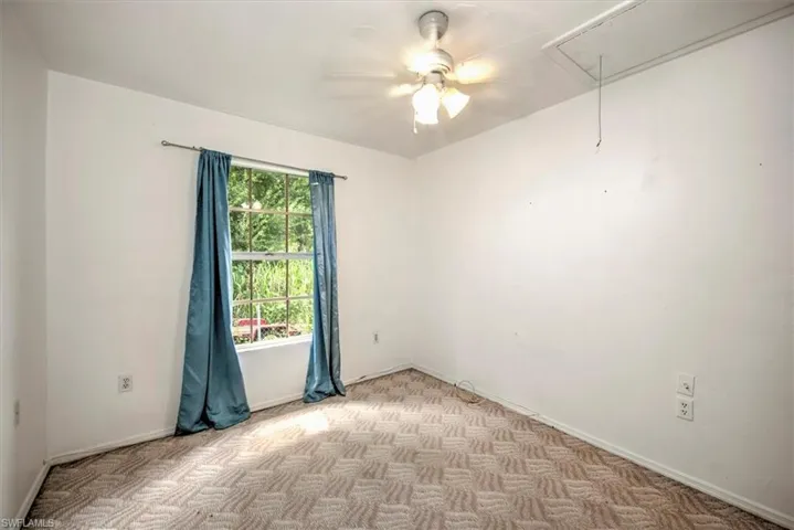 Empty room featuring light carpet and ceiling fan