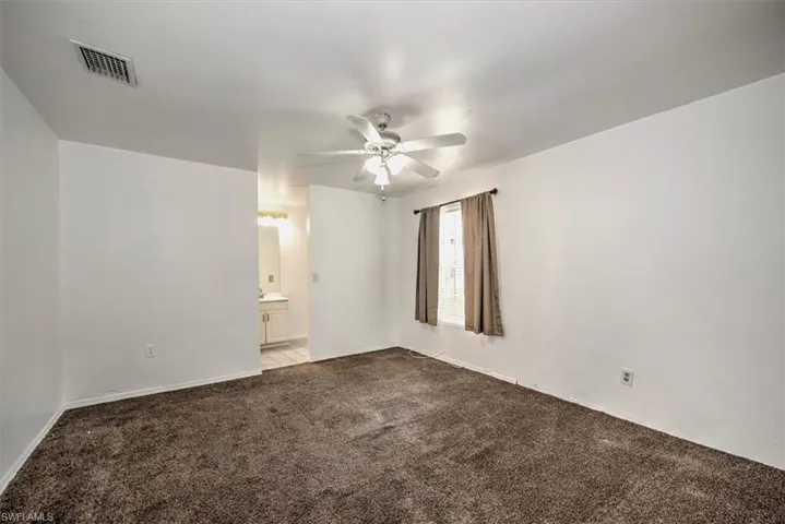 Empty room with ceiling fan and carpet floors