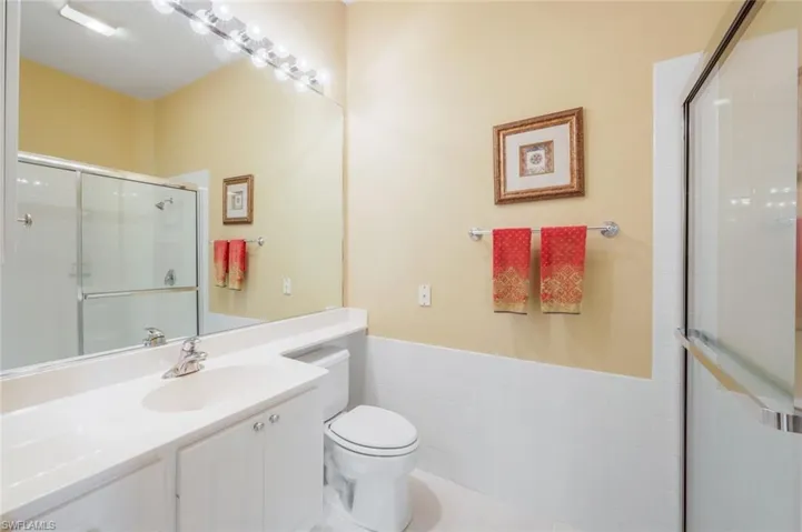 Bathroom with tile patterned floors, vanity, a shower with shower door, and toilet