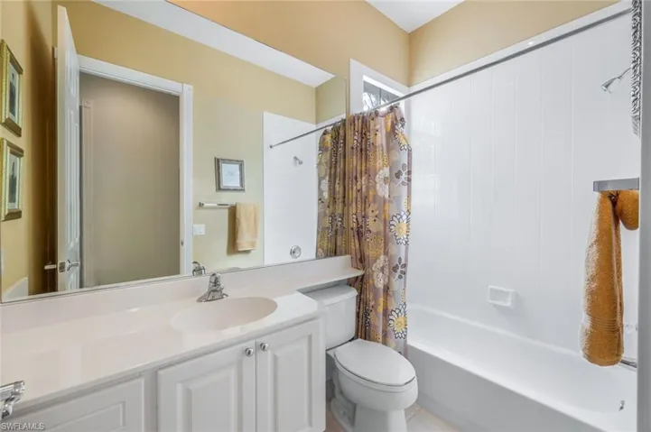 Full bathroom with tile patterned floors, shower / bath combo, toilet, and vanity