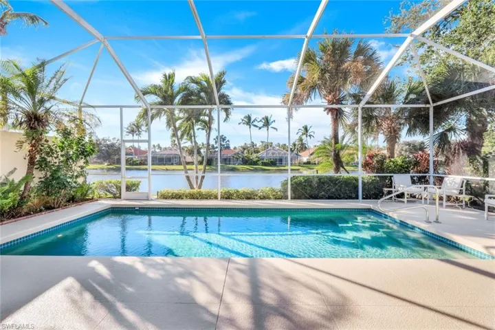 View of swimming pool featuring a patio, a water view, and glass enclosure